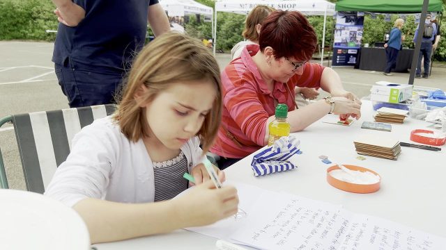Visitors learning arts and crafts skills.